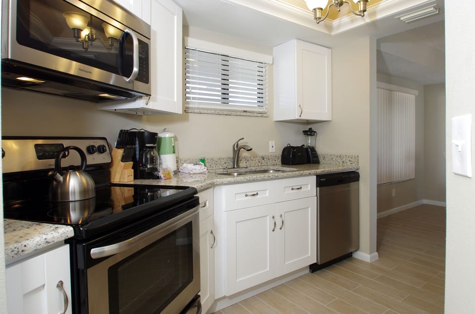 Kitchen is complete with dishware, cookware, coffee maker, blender,  and toaster