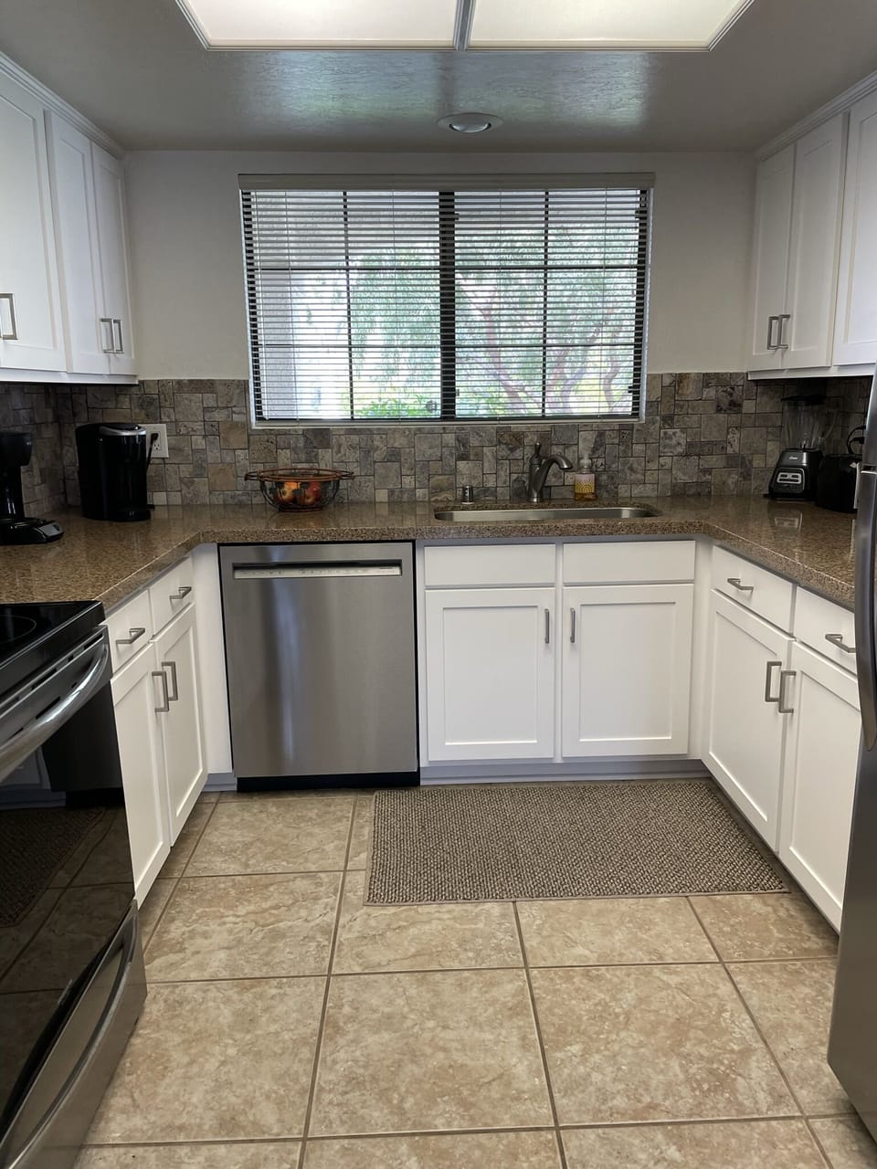 Updated kitchen with stainless steel appliances and quartz countertops.