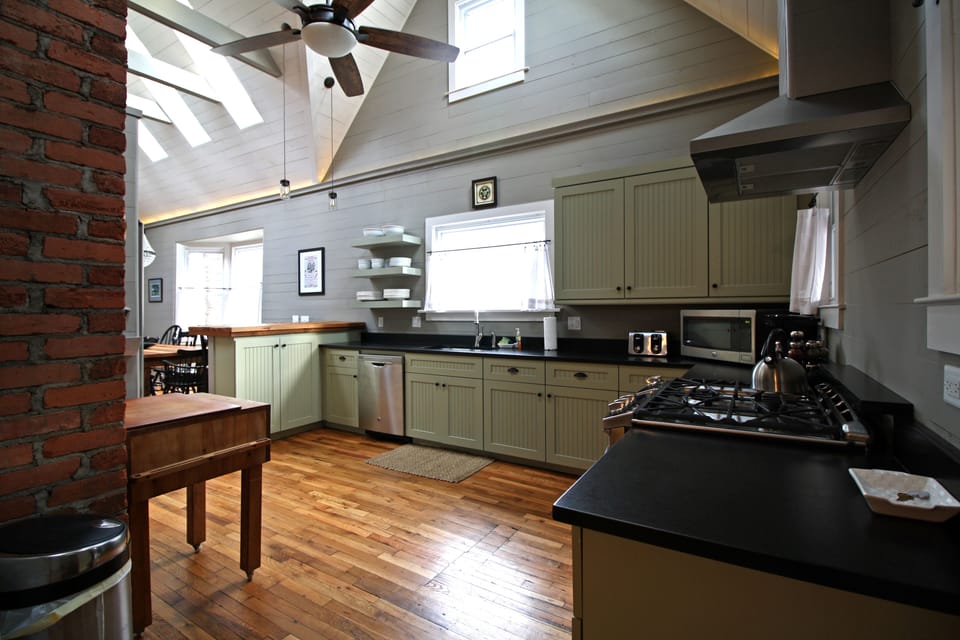 Custom kitchen with stainless steel appliances, gas cooktop, granite countertops