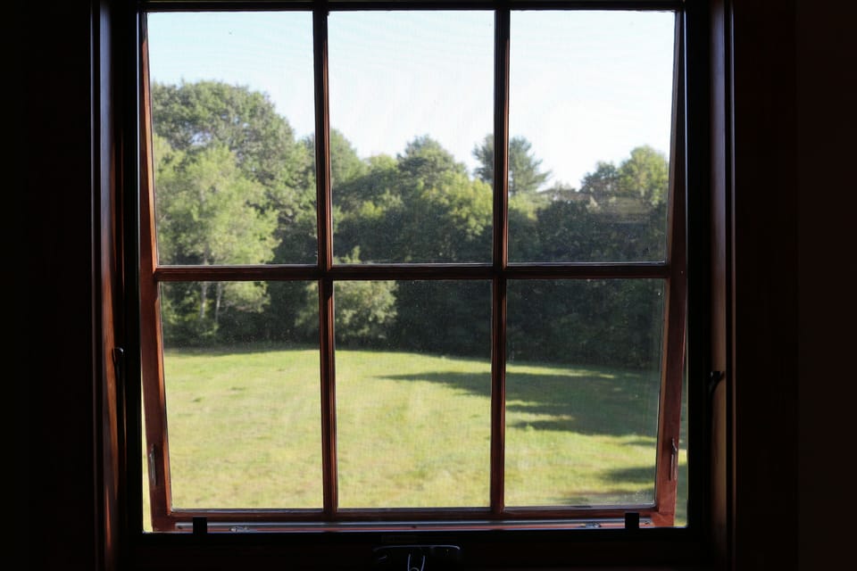 Large awning windows provide views to the meadow and woods.