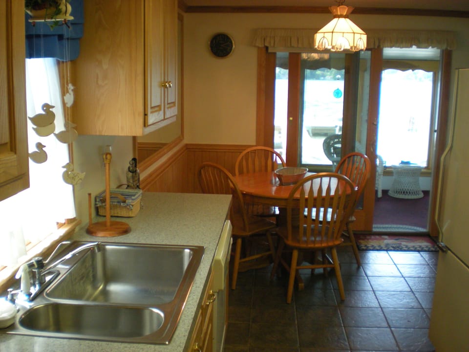 Kitchen w/ eating area view through sunroom to lake