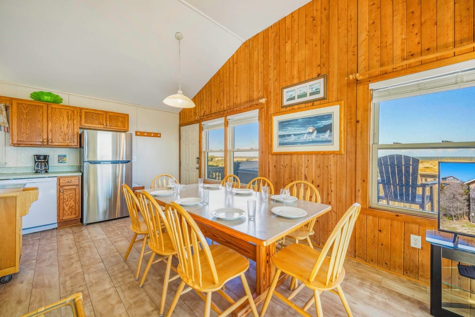 Gather around your spacious dining table where wood-paneled warmth meets stunning views through every window.
