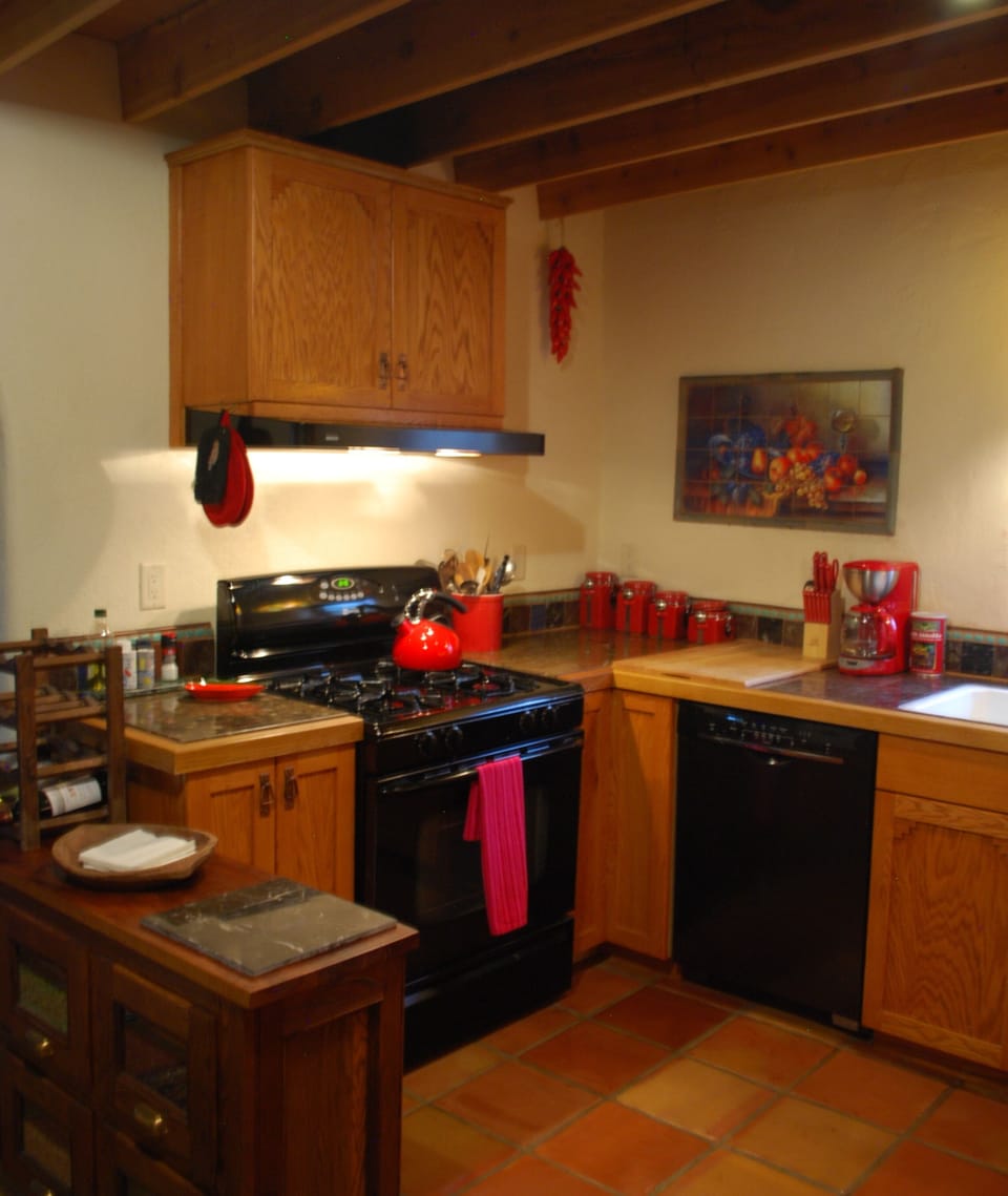 Red and black kitchen with oak cabinets, saltillo tile
