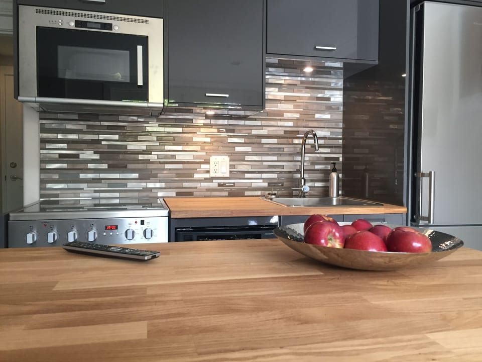 Kitchen includes microwave, dishwasher, fridge, stove and wood-topped island