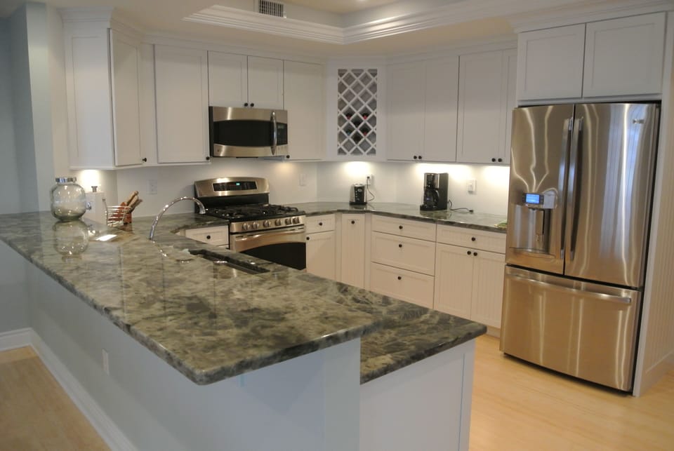 Kitchen with fridge, microwave, gas stove, oven, coffee maker, toaster, and more