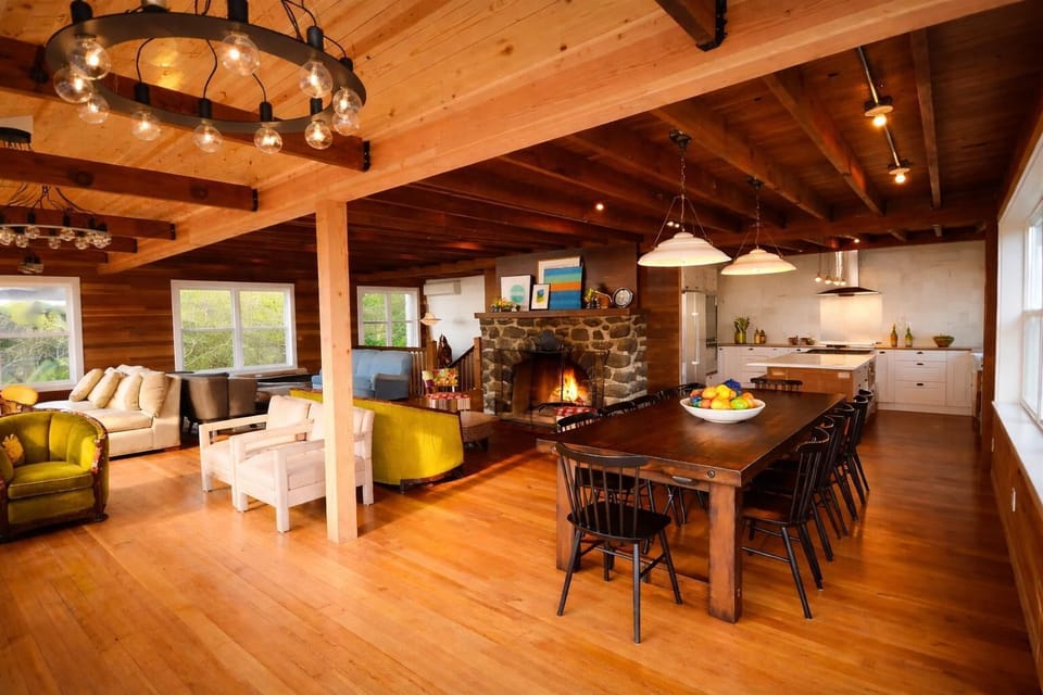 Open-concept great room with the perfect gathering places—fireplace, large dining table, and full kitchen