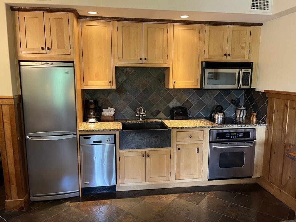 Fully equipped kitchen with alder wood cabinetry and granite countertops.