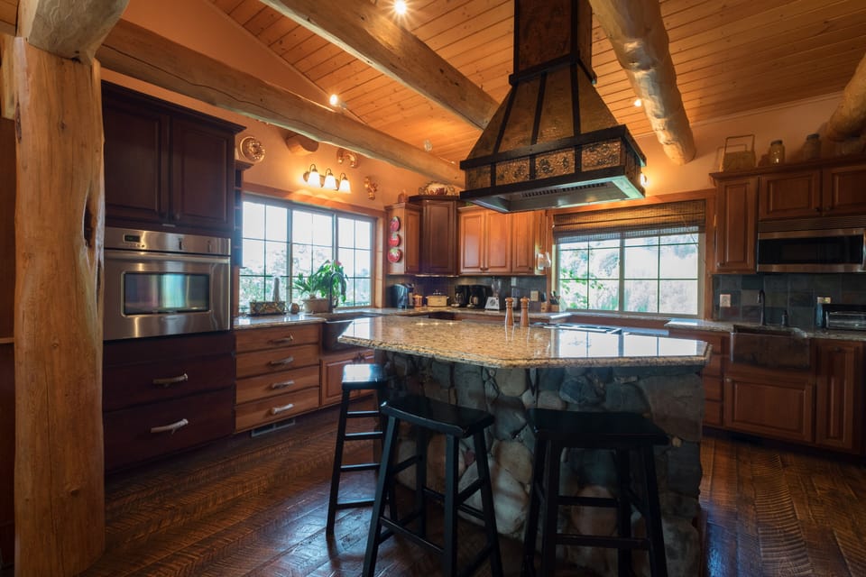 Gourmet kitchen with electric oven, warming drawer, gas range & copper sinks.