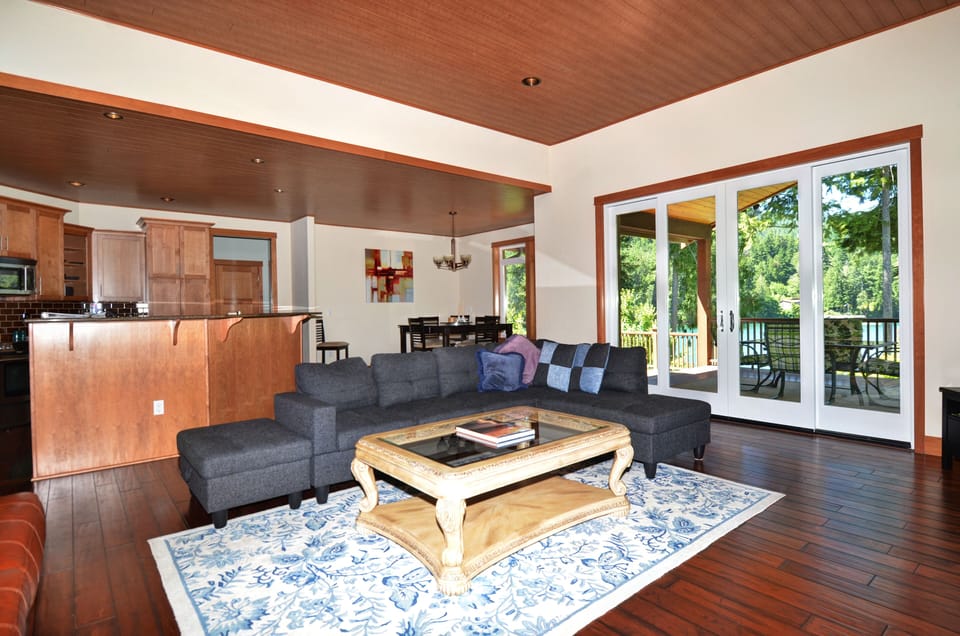 Great room with double doors opening onto covered deck area