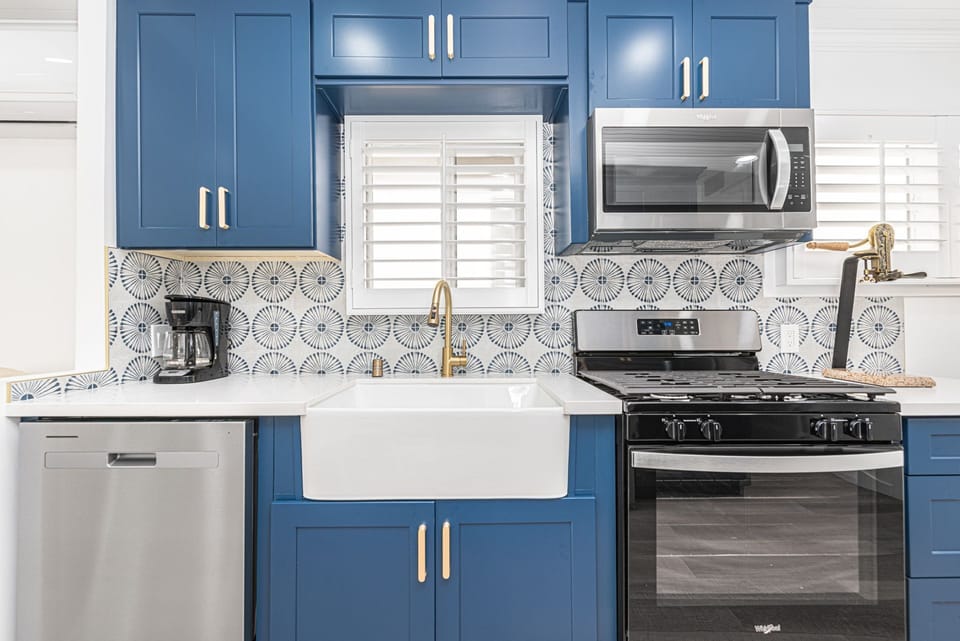 The kitchen comes stocked with dishes, utensils, cookware, bakeware, and large and small appliances. Beyond is access to a private back patio.
                
