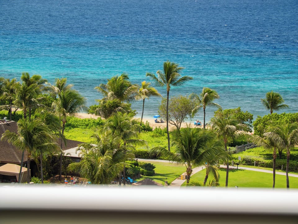 Wake up to stunning views of lush greenery and the crystal-clear waters of Maui's shoreline, just steps away from the sandy beach.