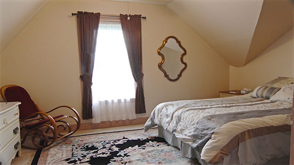Master bedroom with queen-sized bed and view over the town.