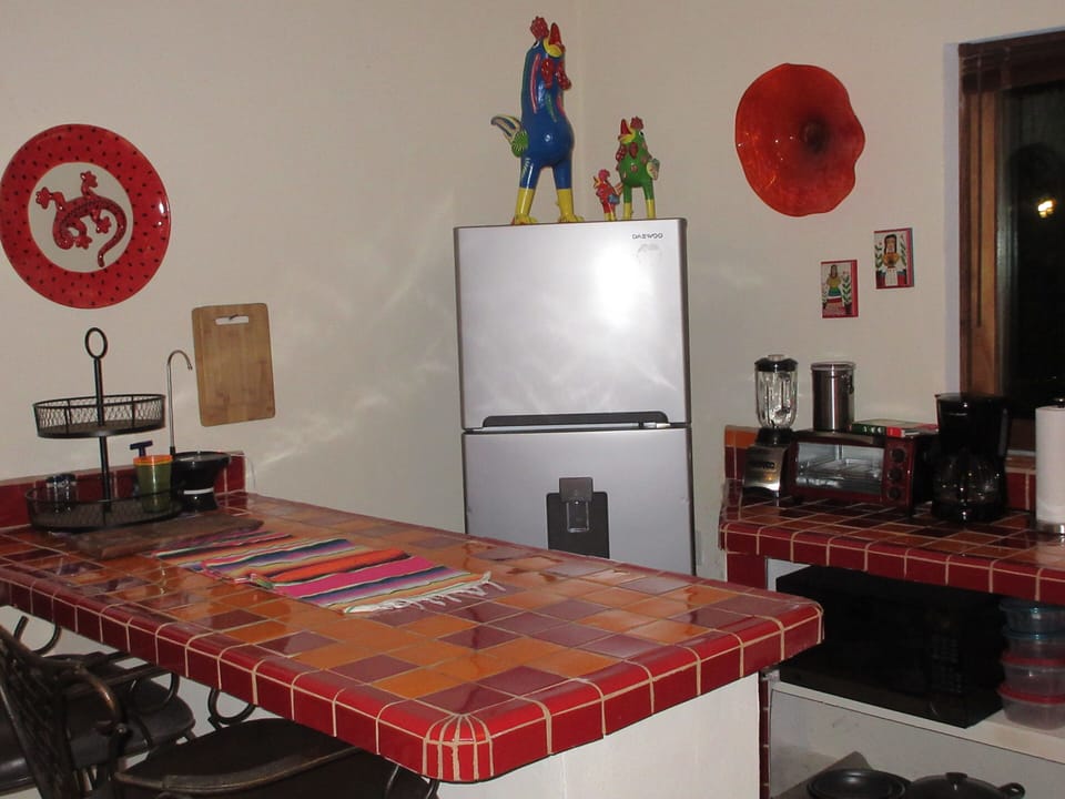fully equipped kitchen with bar and barstools, full size fridge