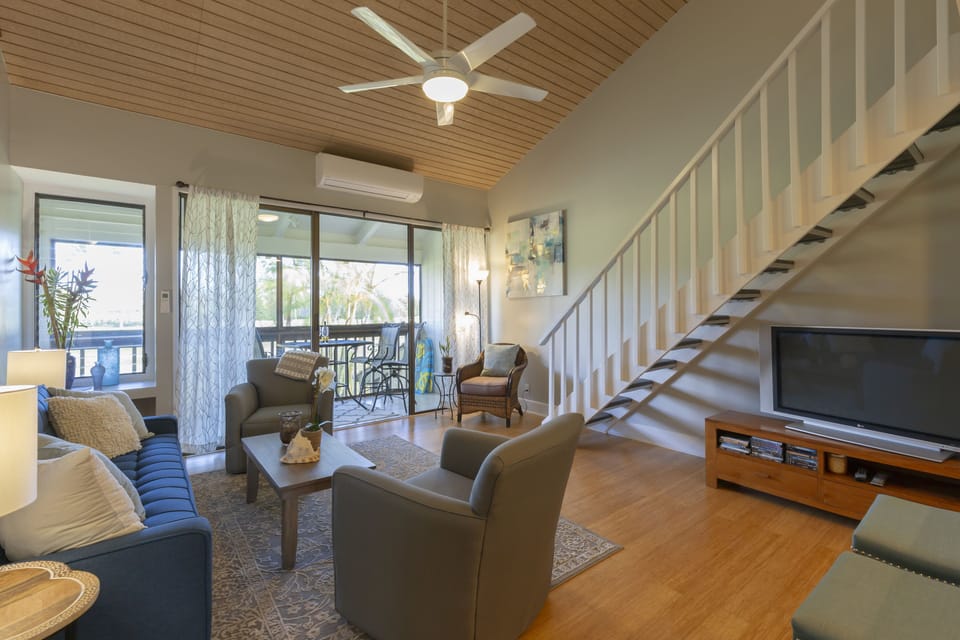 Living room with split AC, golf course view, and stairs to spacious bedroom loft