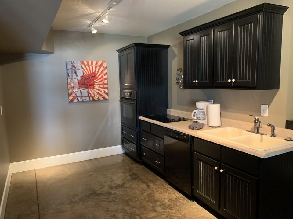 Basement kitchen area includes a sink, dishwasher, stove and oven.