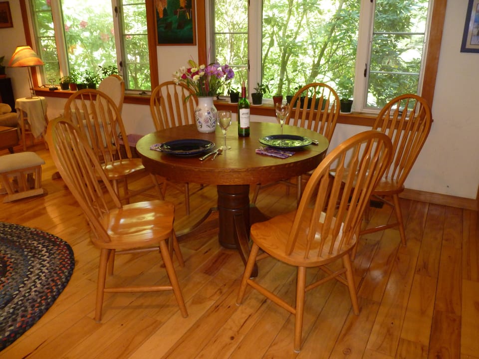 Dining table with exquisite view of rhododendron bushes, bird feeders and trees.