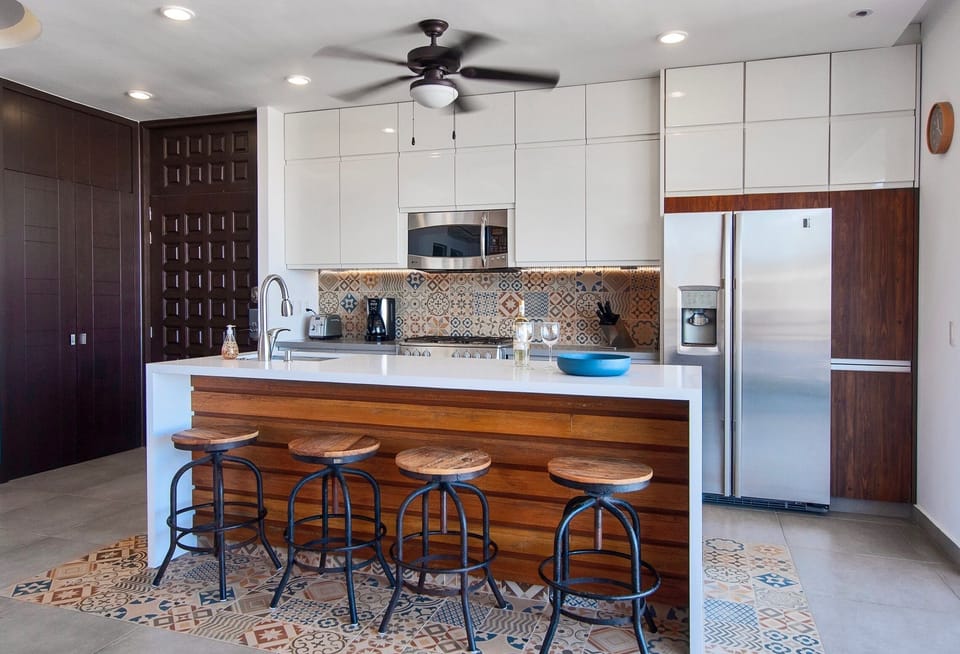 Open island with hidden electric plugs underneath counter for personal devices.