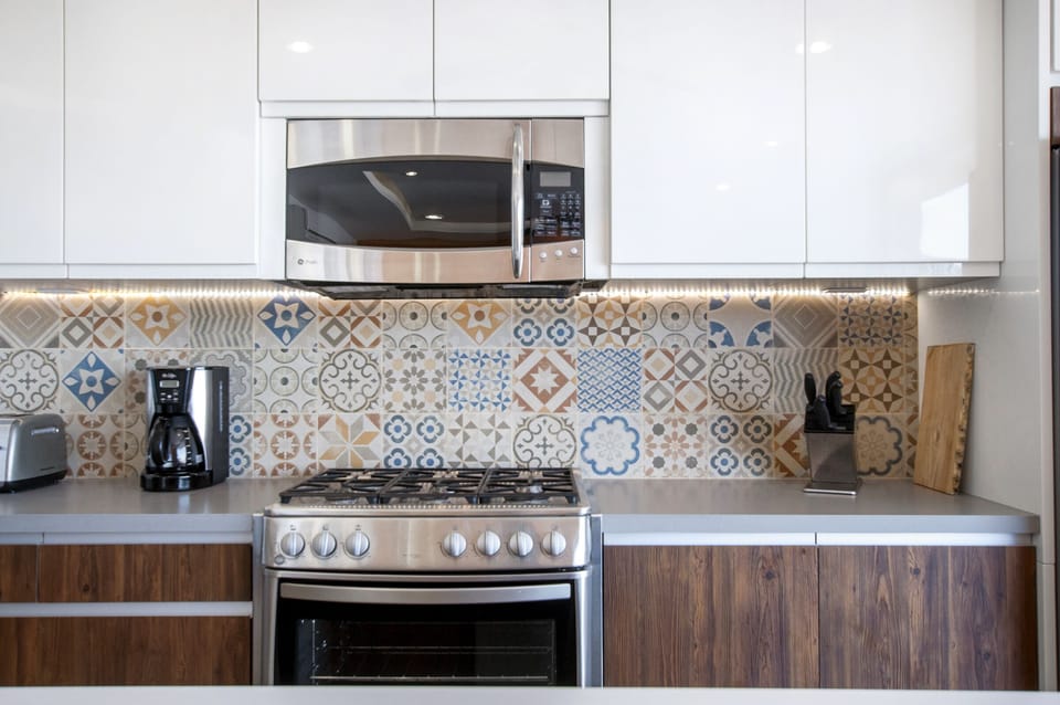 Modern Mexican tiled backsplash with quartz counters.
