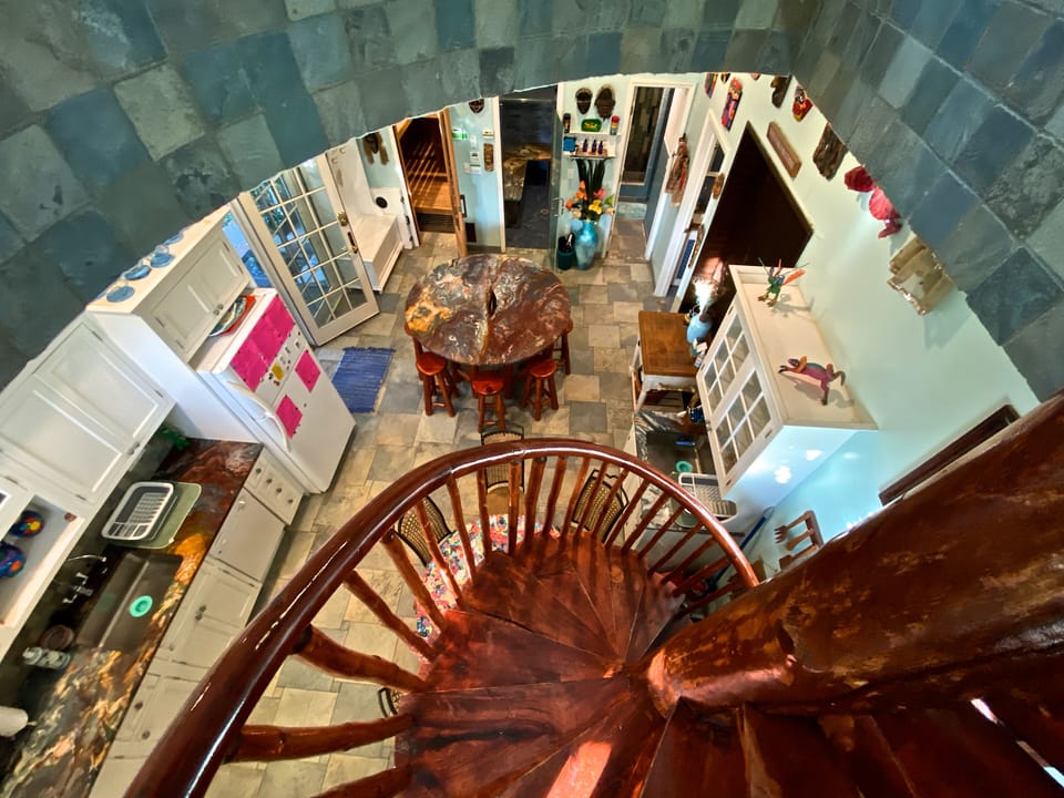 VIEW OF THE KITCHEN FROM THE SPIRAL STAIRS. DOORS LEADING TO: POOL, SAUNA, STEAM