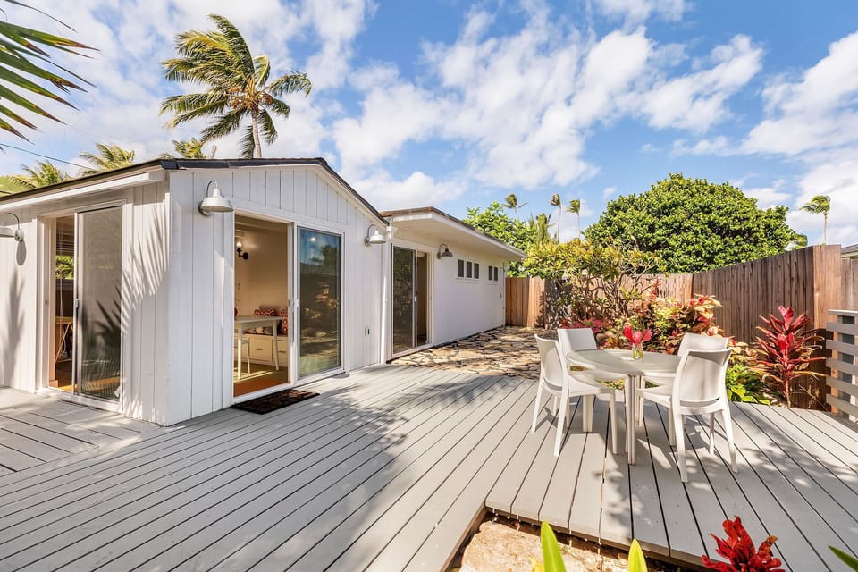 Enjoy extra space and privacy in the detached guest house—complete with its own kitchen, living area, and outdoor seating under swaying palms.