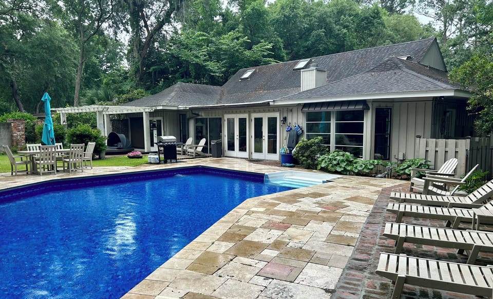Rear view of home with fenced back yard and pool