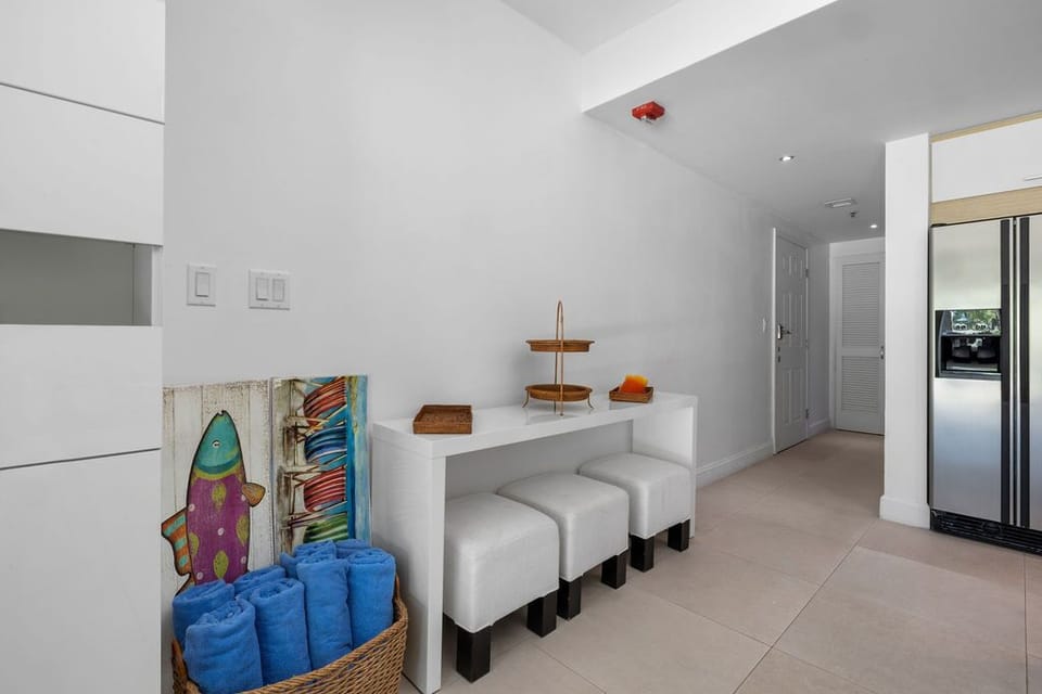 Step into your bright, open space where beach towels, surfboards, and seating await—everything you need for easy island living is right here at your fingertips.