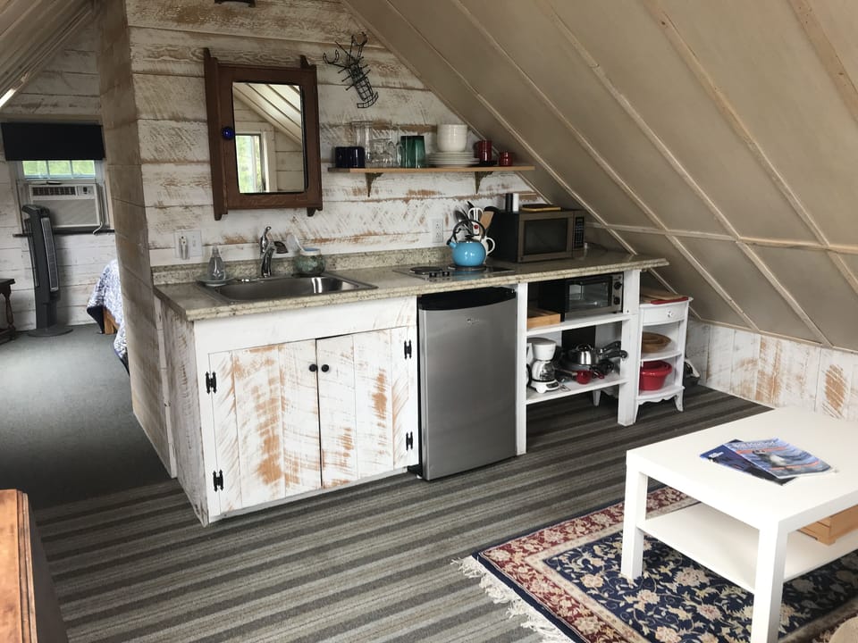 Kitchen with living area to the right, and bedroom beyond to the left.