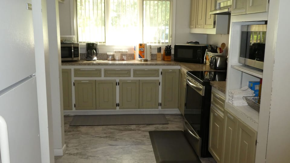 Kitchen with 3 microwaves, 3 coffee makers and 3 refrigerators