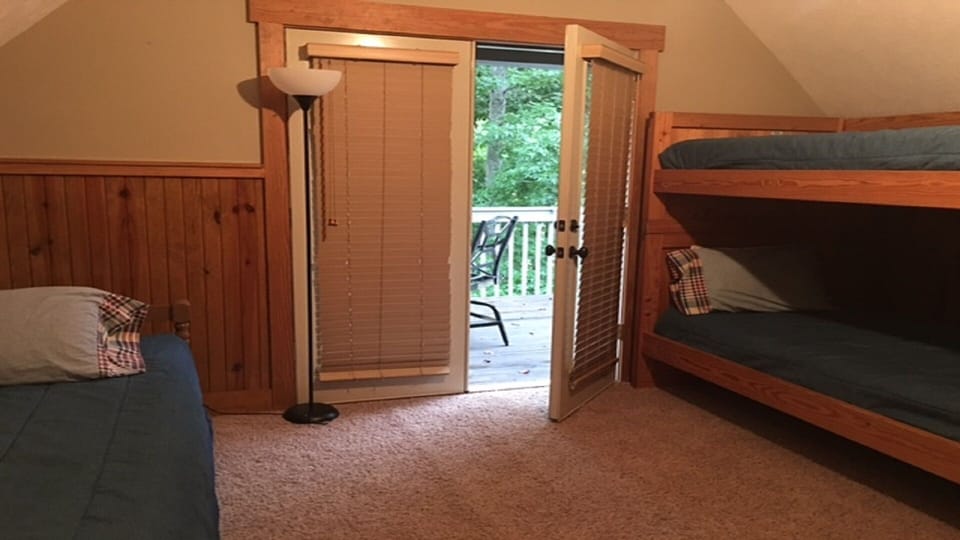 Twin bed with trundle & bunk beds with outdoor deck in upstairs bedroom number 3