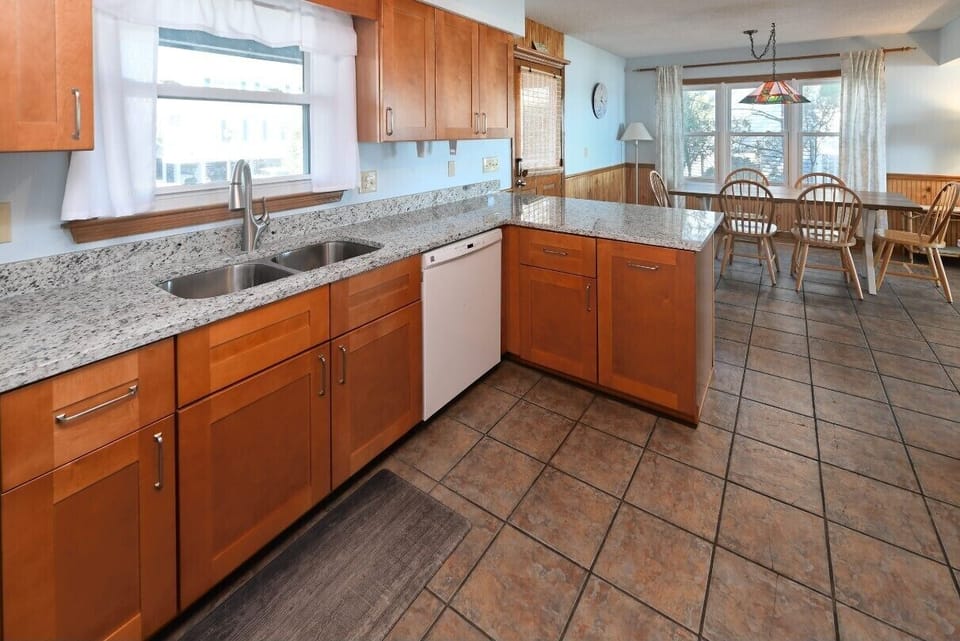 Kitchen with dishwasher, microwave, stainless steel sinks.