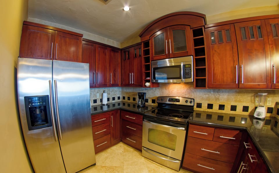 Full kitchen with dishwasher, coffee maker, blender, wine glasses.