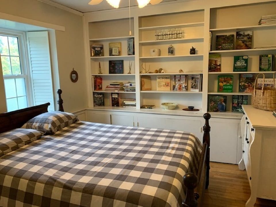 First floor bedroom featuring queen bed next to half bath
