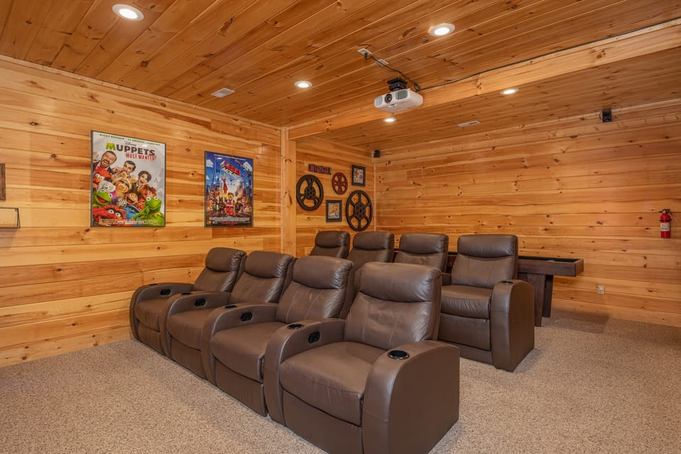 Theater room with tiered seating + shuffleboard + digital pinball game.
