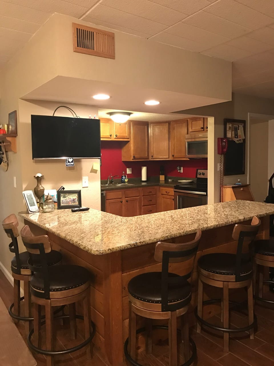 Kitchen view of granite bar/eating area with smart TV 