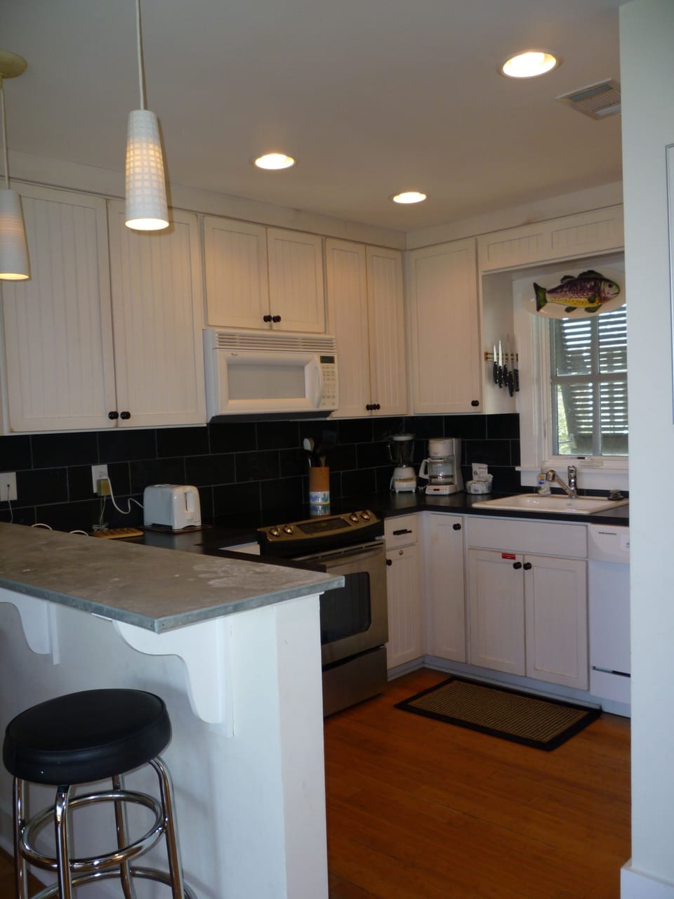 Stainless steel range and oven, microwave, zinc counter.