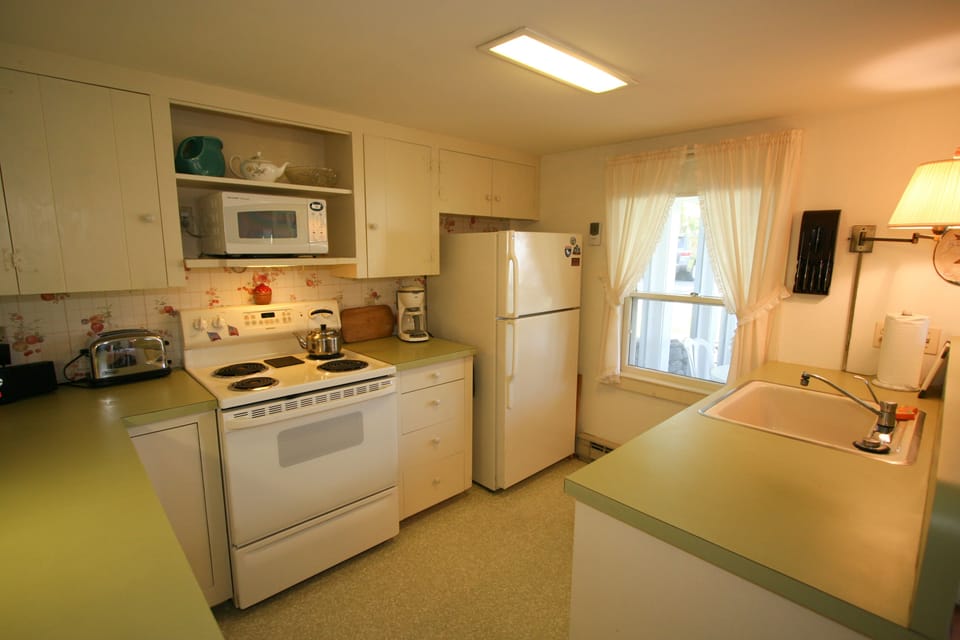 Kitchen has plenty of pots, dishes and utensils, plus dishwasher.
