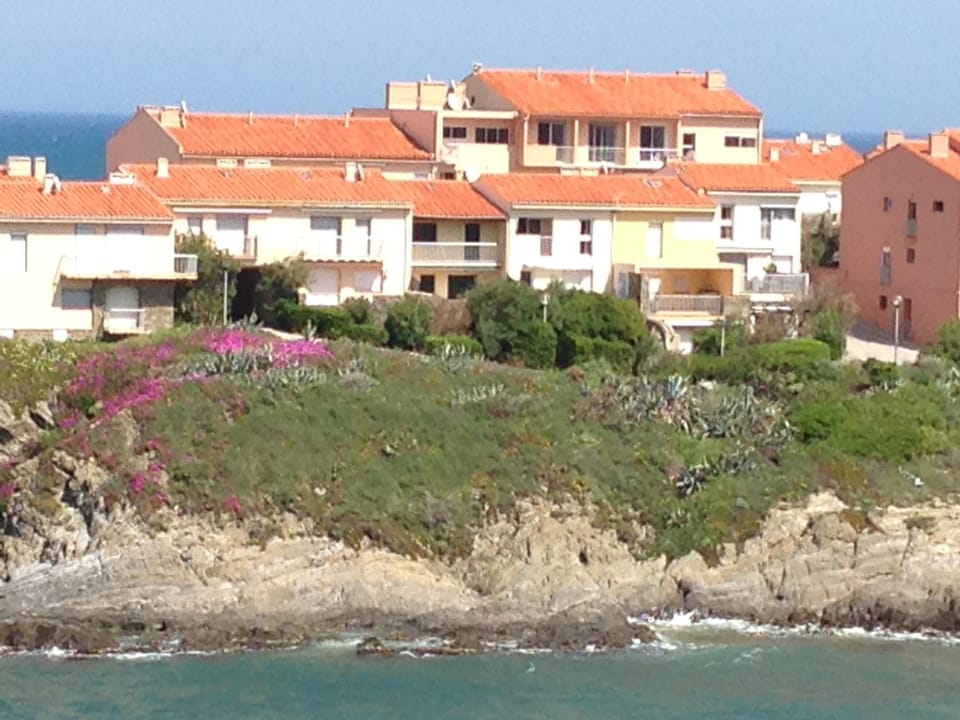 Apartment is highest with flat roof over terrace and two balconies to the right