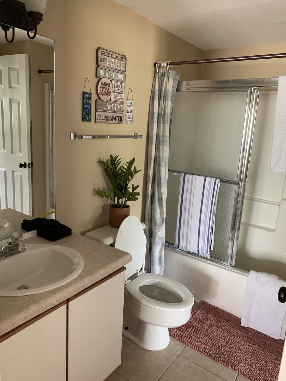2nd bathroom with tub/shower combo. Makeup mirror mounted on wall. 