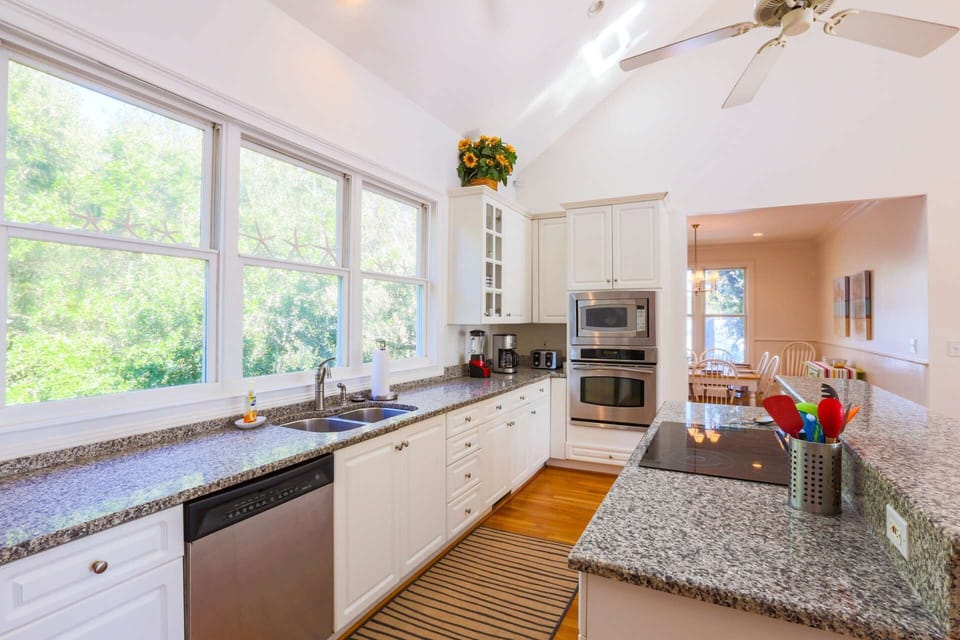 The beautiful kitchen features a cooktop, oven, microwave, blender, dishwasher, toaster, coffee maker & garbage disposal.