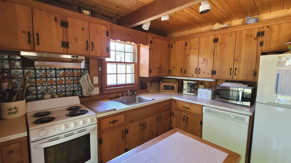 Kitchen has an electric range and dishwasher