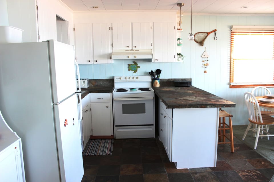 Kitchen is fully stocked with dishes, utensils, and cookware