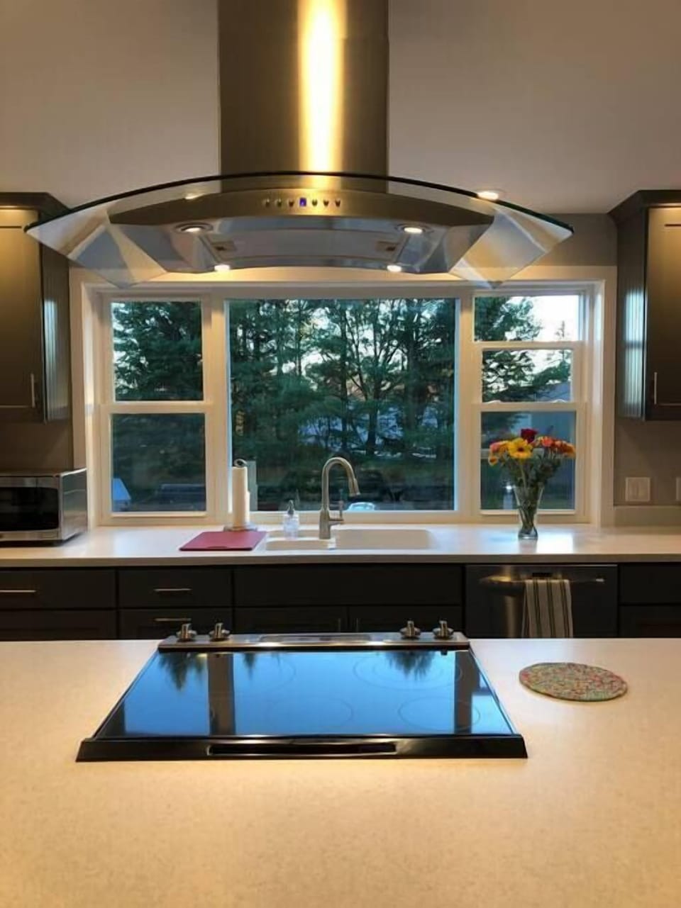 Glass cooktop and hood incorporated into the eat-in bar.