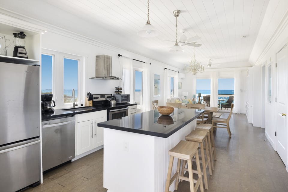 Modern kitchen in black granite and stainless steel, with views of both oceans.