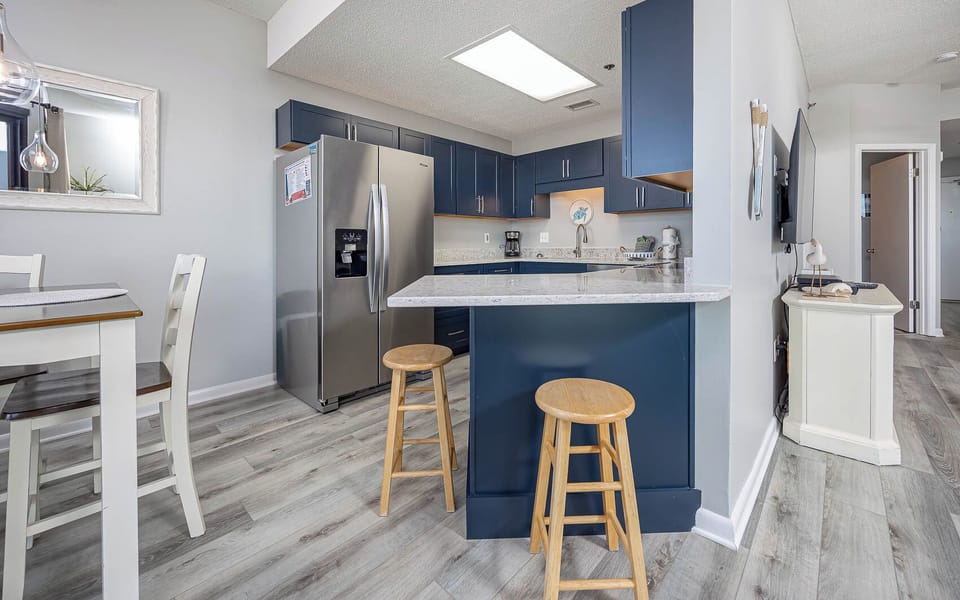 Gather at the breakfast bar or dining table, enjoying the inviting kitchen with modern amenities and stylish decor