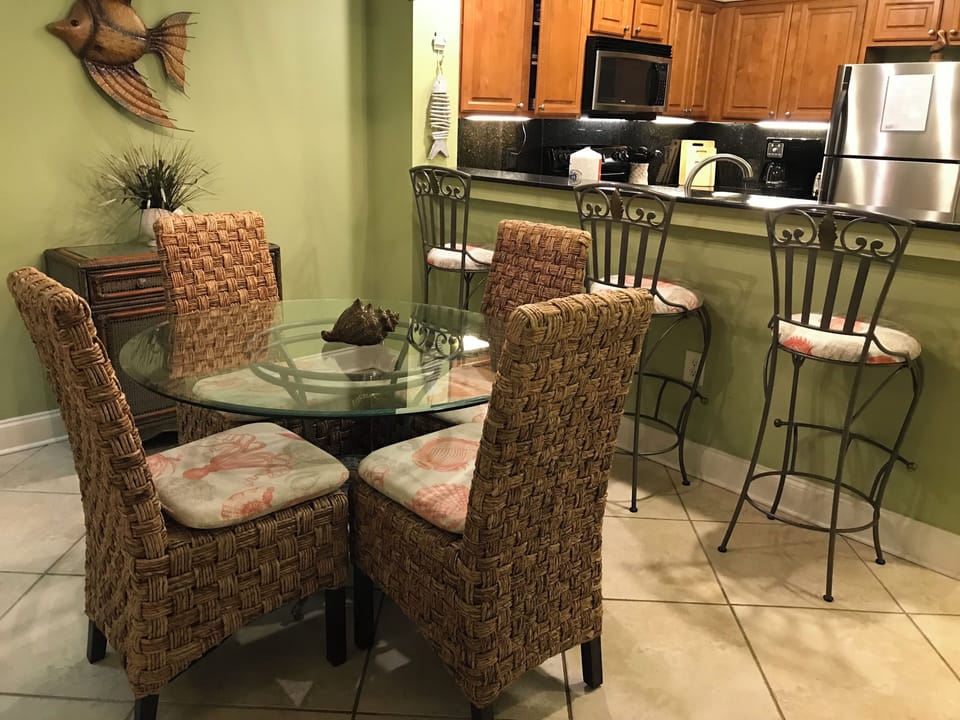 Dining area table for 4 & 3 bar stools. Hutch contains items for entertaining.