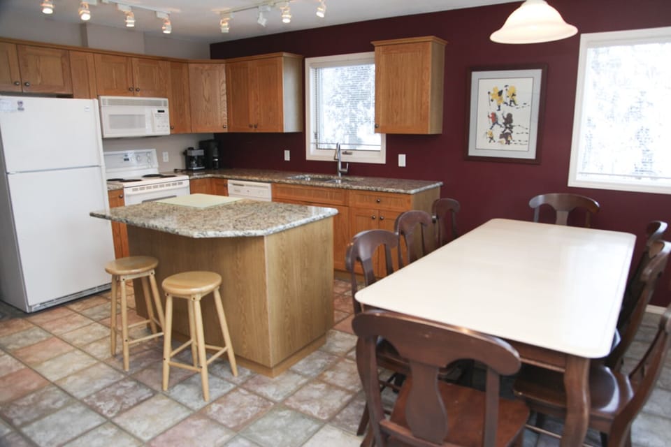 Kitchen with granite counter tops and large table for eight.