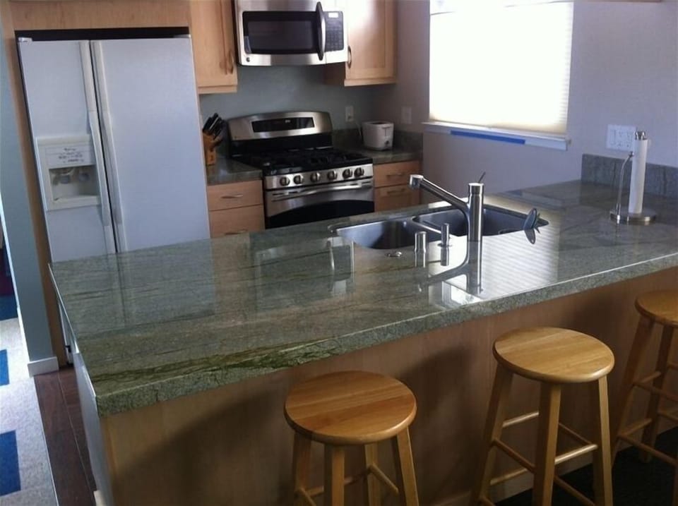 Remodeled kitchen with SEA GREEN counter, new appliances, and counter seating