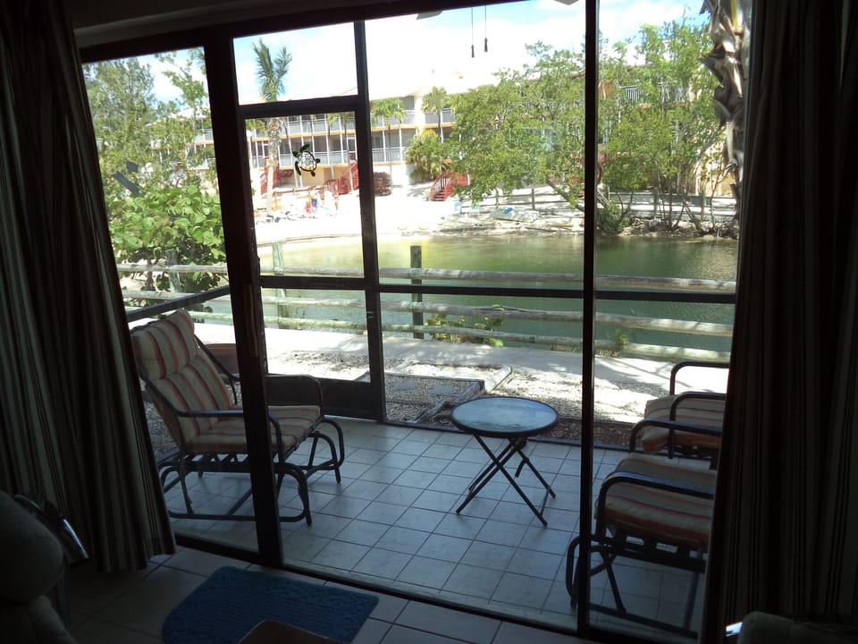 Back screened in porch with view of lagoon and north pool deck