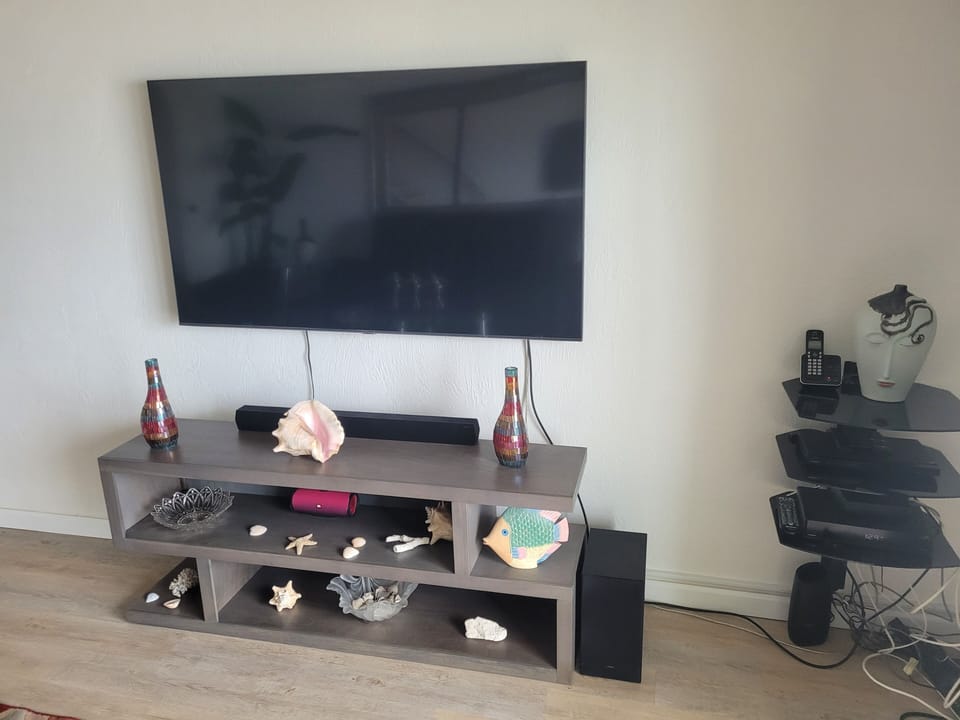 55" TV with Soundbar and table. JBL Wireless speaker to connect to your audio.