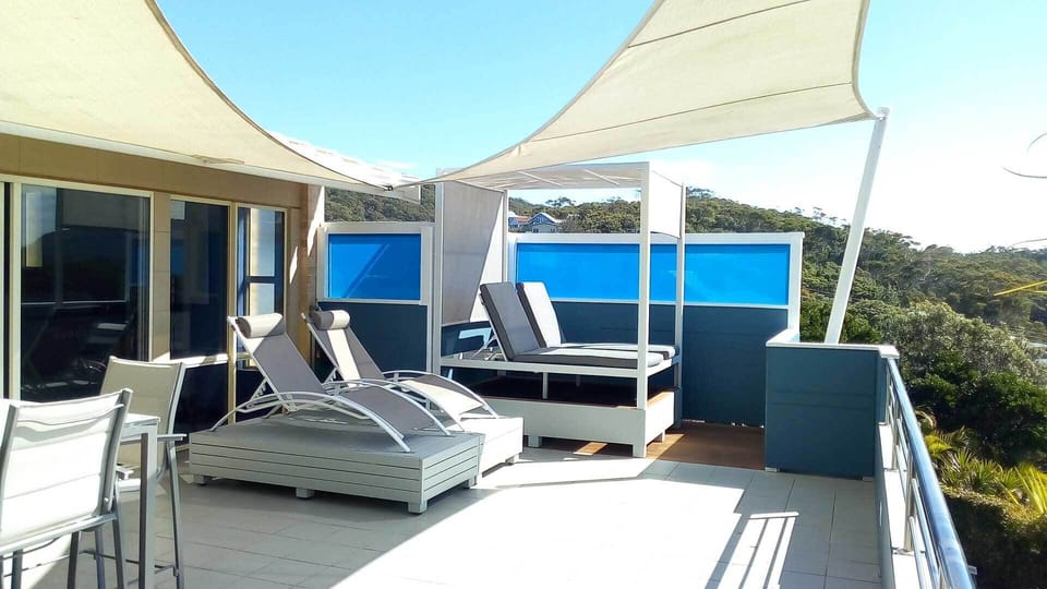Sun lounges and day bed overlooking the sand and surf at Boomerang Beach